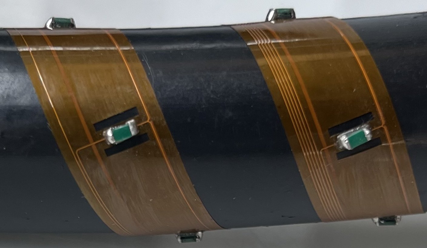 NSI sensors mounted on flexible Kapton circuits wrapped around a pipe, demonstrating integration around curved equipment